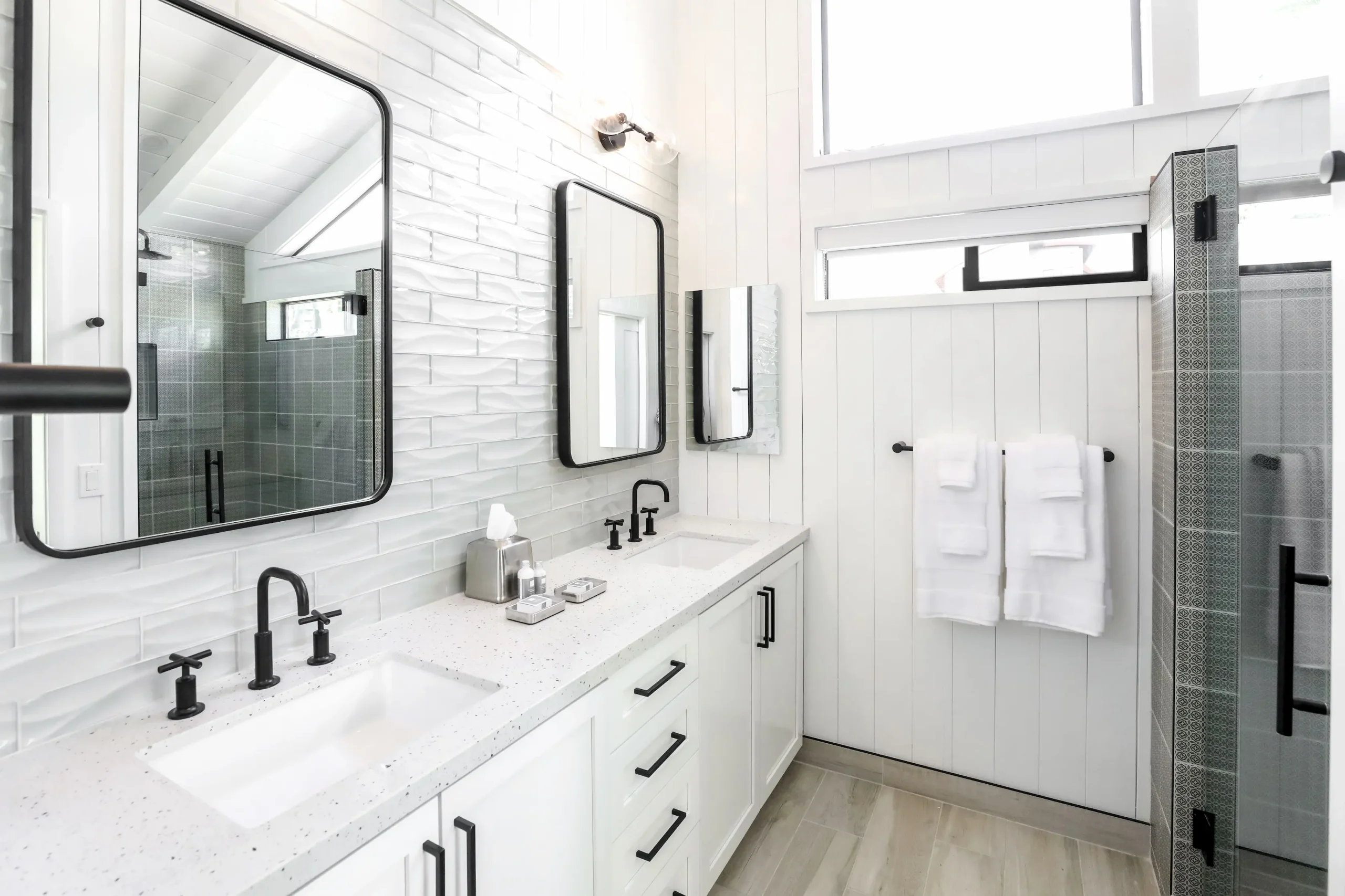 bathoom with white wall and black accents, double vanity and walk in shower